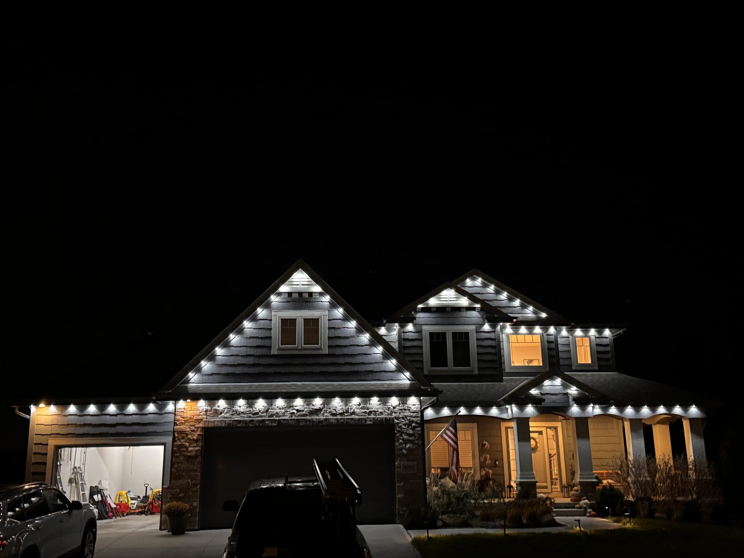 Two story Omaha home outlined in bright white lights along every roofline, peak and dormer